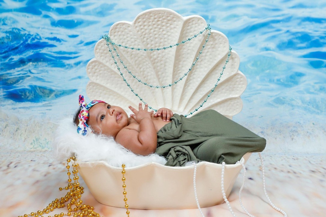 Baby in a shell shaped crib.